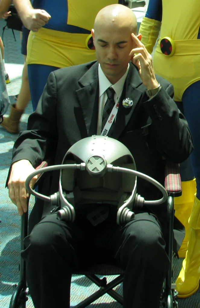 Cosplay del Profesor X de X-Men con traje y casco de Cerebro en una convención.